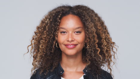 Head-And-Shoulders-Studio-Shot-Of-Woman-Wearing-Leather-Jacket-Smiling-At-Camera-In-Slow-Motion