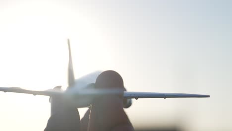 closeup of toy airplane played by hand against sunlight