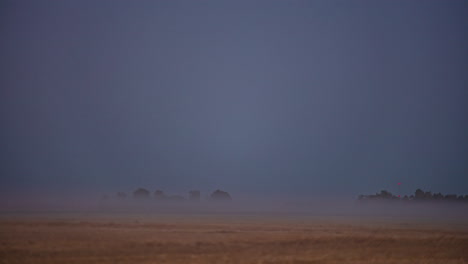 una niebla brumosa se arrastra sobre las tierras de cultivo y luego una superluna se eleva e ilumina el campo - lapso de tiempo