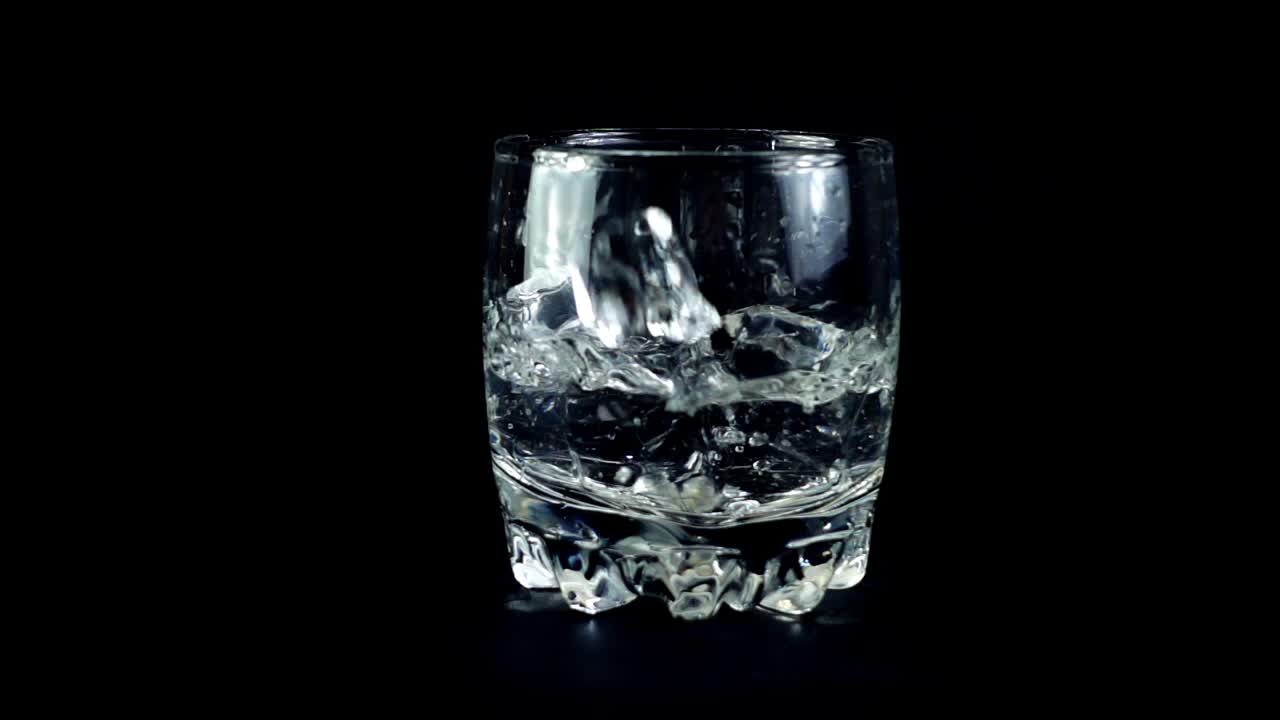 Isterninger falder ned i et glas. Slowmotion