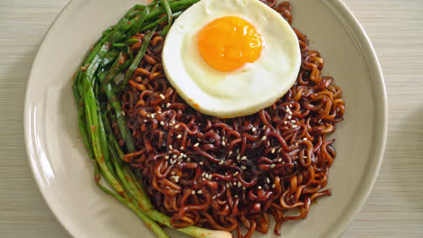 homemade dried korean spicy black sauce instant noodles with fried egg and kimchi