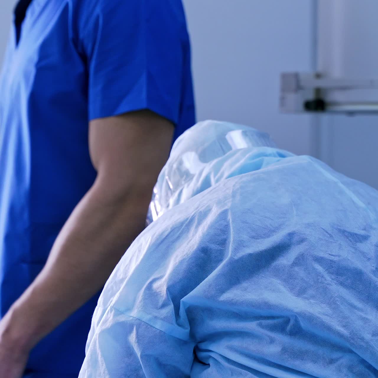 Nurse in protective uniform working with syringe. Doctor's asistant in safety suit and facial mask in clinic. Covid-19 concept.