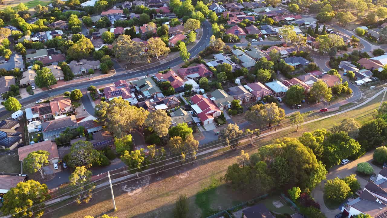 Ripresa aerea con drone di case residenziali e alberi verdi a Canberra durante la calda ora d'oro