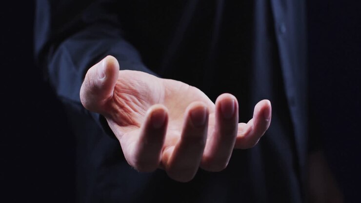 Hand van een Kaukasische man met handpalm omhoog die een onzichtbaar object vasthoudt.