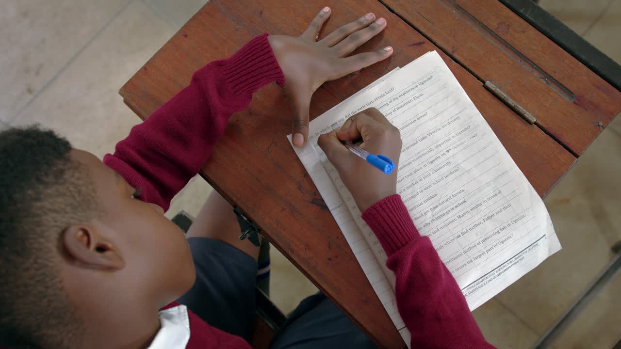 Student Taking Exam, Writing Answer In Classroom In Africa - High Angle Shot