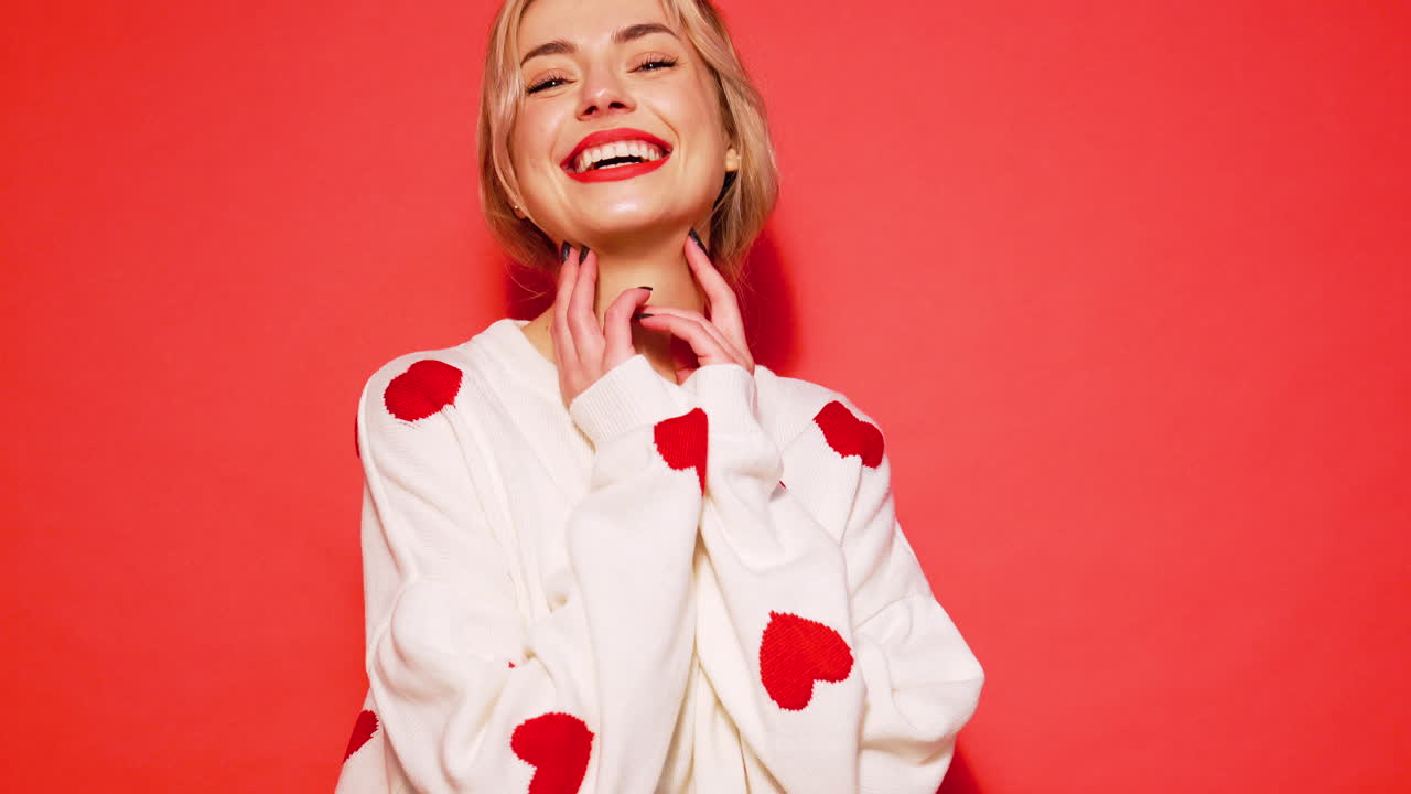 은 심장이 있는 색 스웨터를 입은 행복한 여자