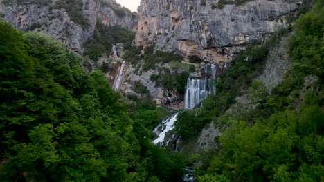 aerial view discovering peshtura waterfall and karst gorge in albania at golden hour