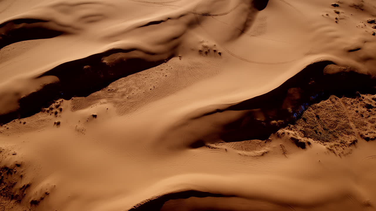 Looking down from above, the drone records swirling patterns and pink sands in southern Utah.