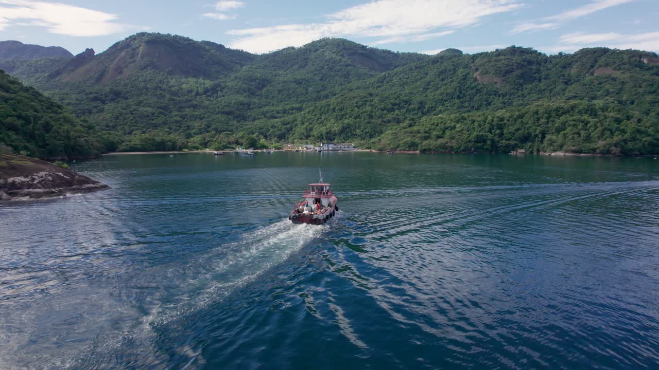 tiro de seguimiento del bote de basura que va hacia la isla de ilha grande para recoger basura, brasil