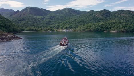 tracking shot of garbage boat going towards ilha grande island to collect trash, brazil