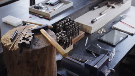 Close up of handcraft tools lying on tree trunk in studio in slow motion