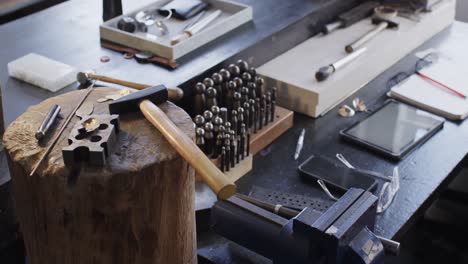 close up of handcraft tools lying on tree trunk in studio in slow motion