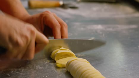 female baker cutting pasta in bakery shop 4k