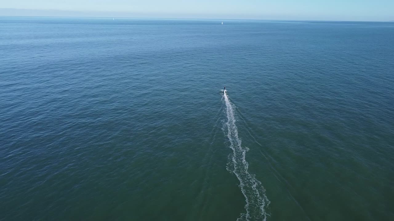 Motorboat floating in rippling sea under blue sky