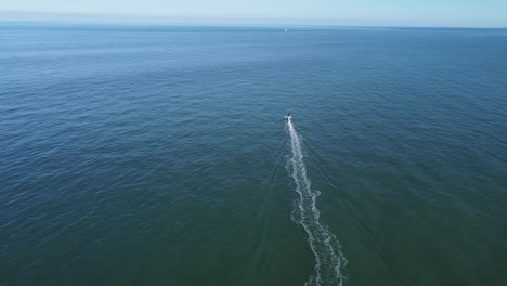 motorboat floating in rippling sea under blue sky