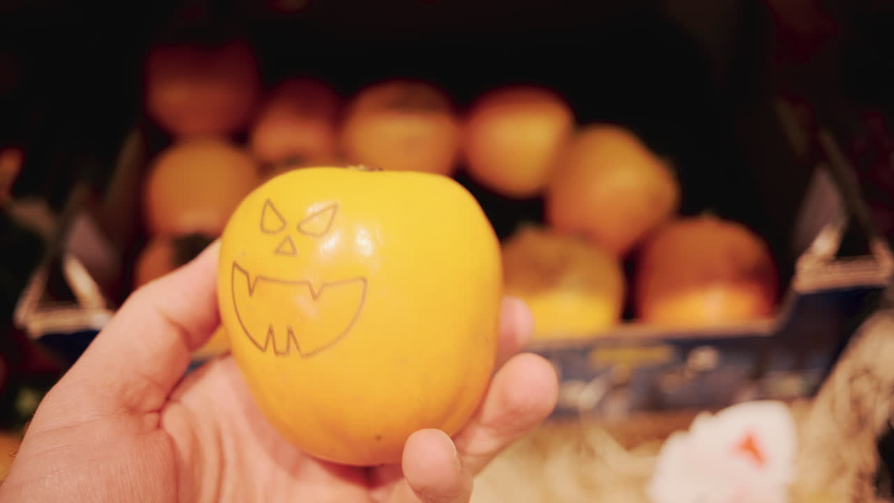 Close up of a person selecting fresh kiwi fruit from a pile in a supermarket