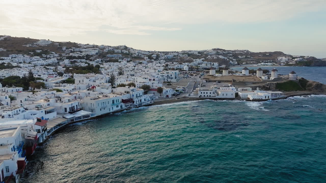 Case tradizionali imbiancate a calce sull'isola di Mykonos, sulla costa del Mar Egeo, con vista su Piccola Venezia, famosi mulini a vento in vista, ripresa con drone