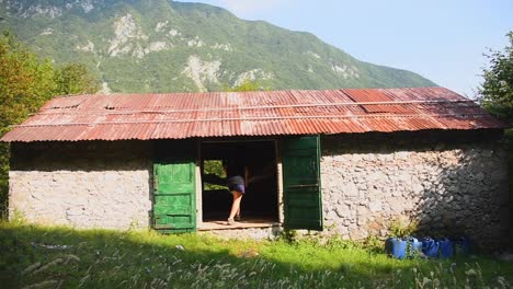 mujer joven entrando dentro de una cabaña de montaña y sentada en una hamaca