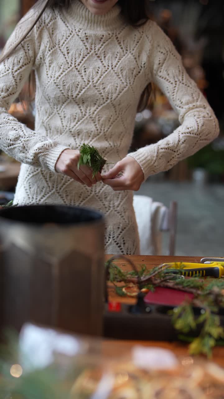 mujer creando un arreglo floral navideño festivo