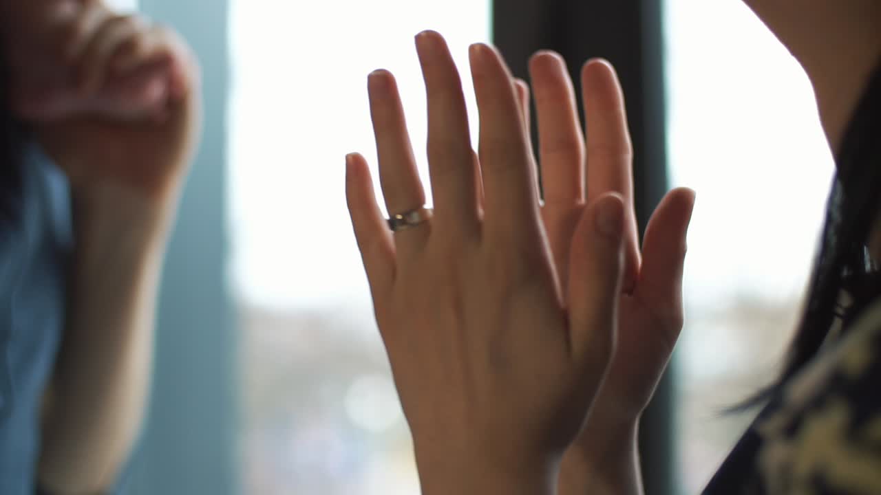 A person's hands near a window