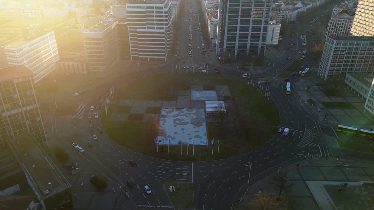 Cars driving around ernst reuter platz in berlin, germany during golden hour. Smooth aerial view flight drone shot footage from above
