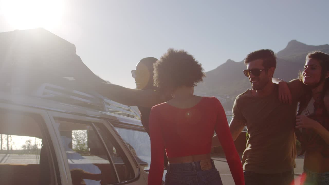 amigos cargando equipaje en el estante del techo del coche listos para el viaje por carretera