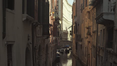 Wide-tilt-up-shot-of-Calm-water-in-canal-street,-Venice,-Italy