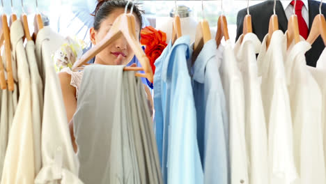 pretty fashion designer looking through her clothing rail