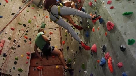 Men-and-woman-climbing-an-artificial-wall-at-bouldering-gym-4k