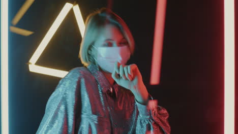 woman dancing in neon lights wearing a mask