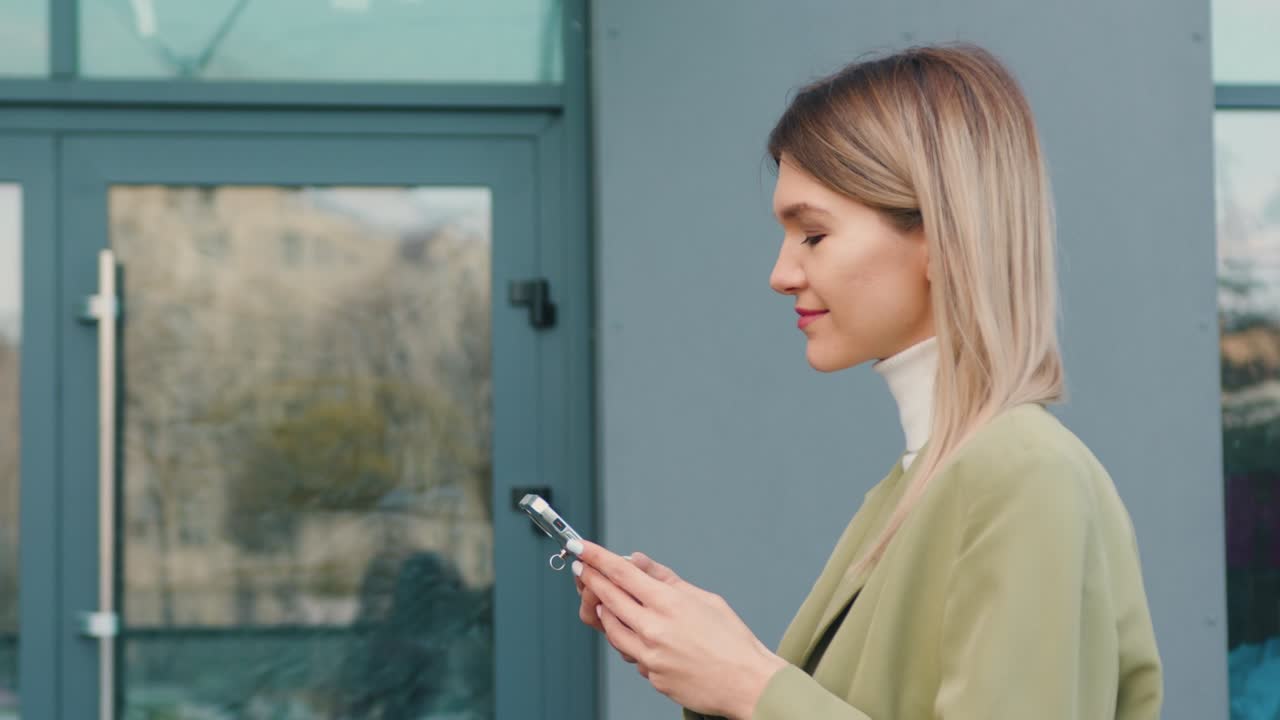 Close up successful woman walks on street with smartphone and chatting with friends using smartphone. Communication, social networks, online shopping concept