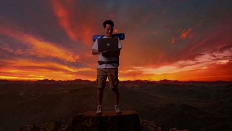 nómada digital en la cima de una montaña al atardecer