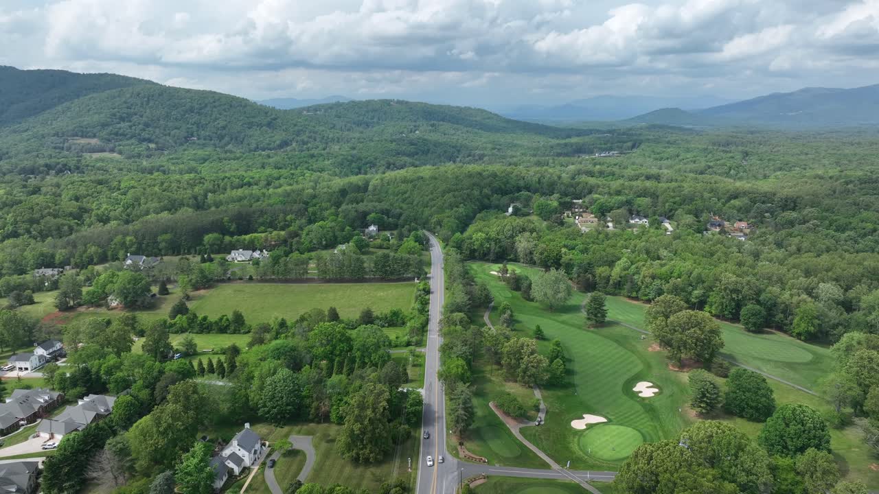 Main street suburb street of american town with green mountains. Golf Course at Boonsboro Country Club. Ascend aerial wide shot.