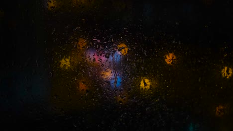 luces de la ciudad de la noche lluviosa a través de una ventana