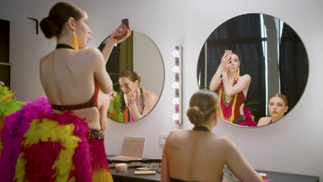 three showgirls applying makeup in the backstage 1