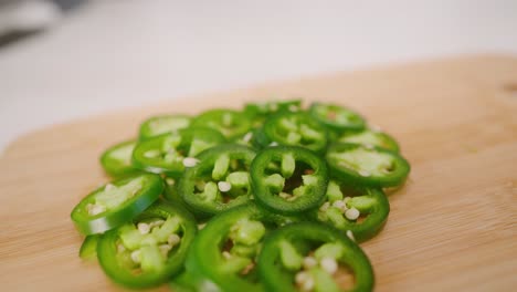 Driften-Sie-In-Zeitlupe-über-Einen-Hellgrünen-Haufen-Frisch-Geschnittener-Jalapeños-Auf-Einem-Schneidebrett-In-Der-Küche