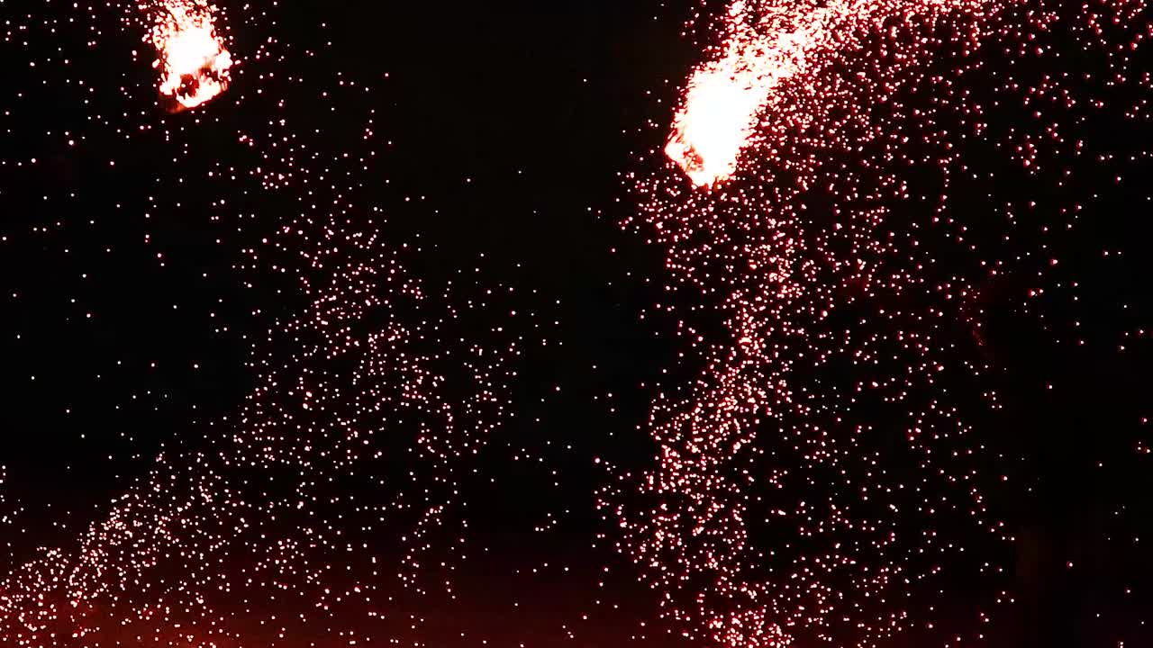 Captivating trails of fire create stunning patterns against a dark backdrop, showcasing dynamic movement and glowing sparks.