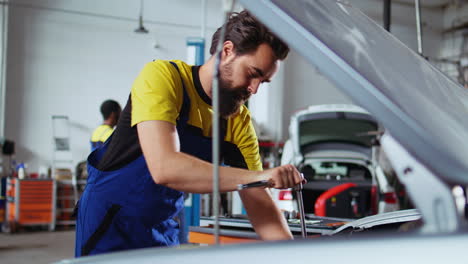el reparador reemplaza el motor del coche en el garaje