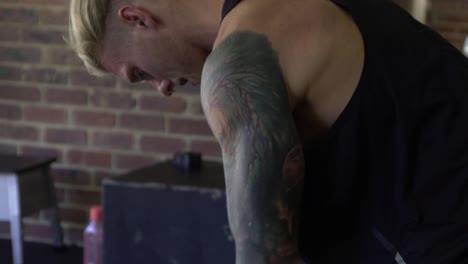 muscly man in home gym exercising barbell row