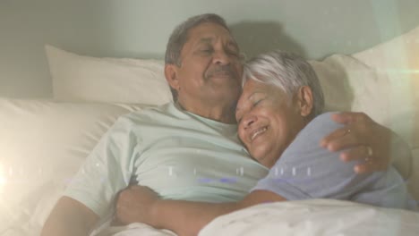 Animation-of-glowing-lights-over-happy-senior-couple-lying-in-bed-in-background