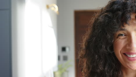 retrato de una mujer biracial feliz con el cabello rizado en casa, espacio de copia, cámara lenta