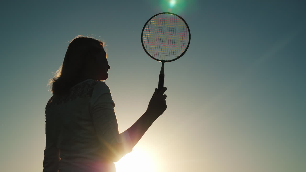 테니스 라켓 활성 스포츠 여름 휴가 개념 4k 비디오와 중년 여성의 실루엣