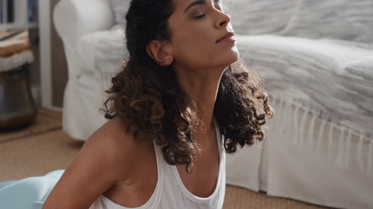 bella donna che si esercita a casa praticando yoga in salotto godendosi l'allenamento fitness mattutino 4k