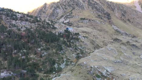 Refuge-Espingo-shelter-at-Lac-d'Espingo-lake-in-Haute-Garonne,-Pyrénées,-France,-Aerial-approach-shot