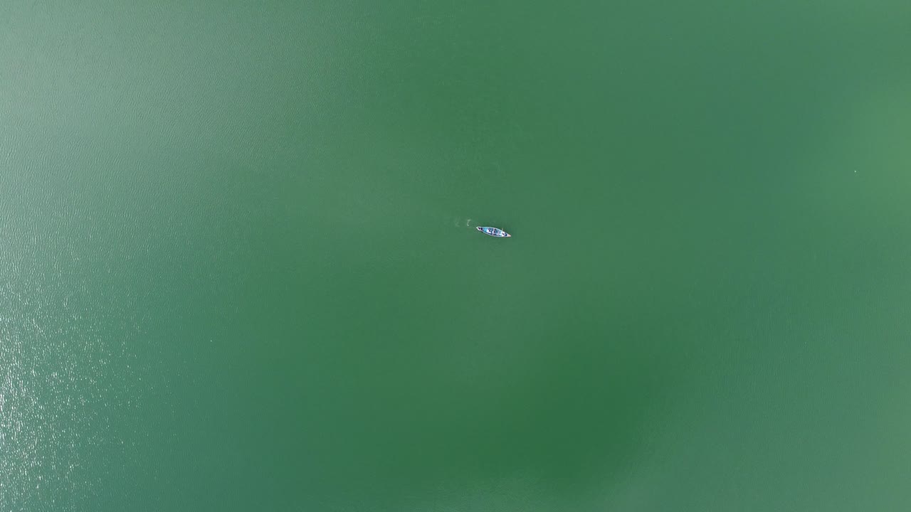 vista aérea de un barco de pesca en un lago o mar turquesa