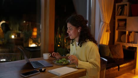 mujer cenando mientras está en una llamada de video