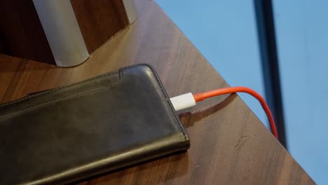 red usb cable inserted to phone for charging, close up