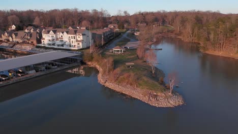 Aerial-drone-footage-flying-over-lake-towards-a-point-of-land-with-calm-water-and-nice-houses