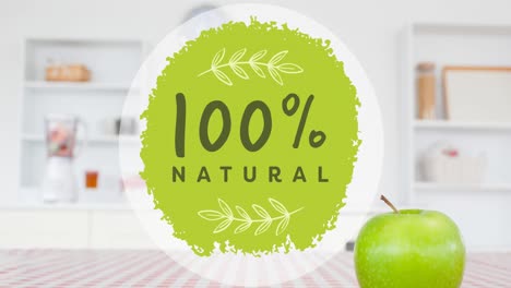 animation of 100 percent natural text in green, over apple on table in kitchen