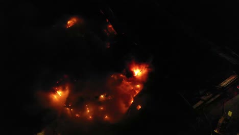 aerial view above a building fire, during dark nighttime - top down, drone shot